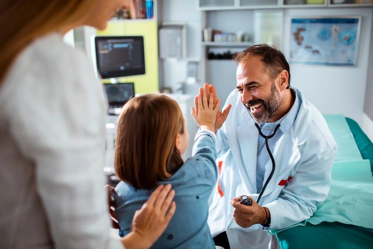 Image of a doctor high fiveing a young child